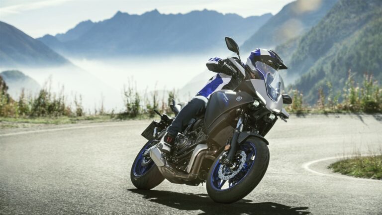 Man sieht auf dem Bild einen Motorradfahrer, der mit einer Yamaha Tracer 700 über eine bergige Landstraße fährt. Zubehör und Ersatzteile für Yamaha Tracer 700 Motorräder gibt es bei Motorradheld